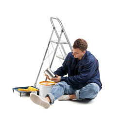 Sticker - Young man with ladder and cans of paint sitting on white background