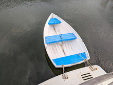 A dinghy in the water behind a boat. 