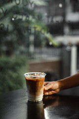 Wall Mural - ice latte coffee in plastic glass on black table at cafe​