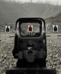 Assault rifle red dot target view, image of a rifle scope sight used for aiming with a assault weapon rifle at shooting range