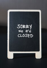 Black small chalkboard with handwritten text SORRY WE ARE CLOSED, concept of business ,store,shop inform customers they are closed, or out of business