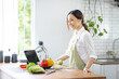 © David - Portrait of attractive asian japanese woman in kitchen at home, young girl browsing website on tutor cooking class and doing for kitchen, cutting vegetables, cooking, cooking concept.
