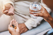 © C Davids/peopleimages.com - Hands of nurse with patient for pills, water and medication in nursing home for wellness, healthcare and prescription. Doctor, medical care and health worker with vitamins, supplements and treatment