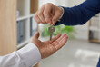 © Studio Romantic - Realtor handing over the keys to a new home owner. Real estate agent gives the key to the buyer. Young man takes keys to his newly bought house or apartment. Cropped close up shot. Real estate concept