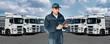 © scharfsinn86 - Manager with a digital tablet next to trucks. Fleet management
