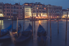 Venice Canal With Historical Buildings And Gondolas At Night. Italy.