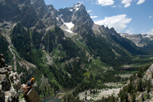 A Rock Climber Belays From A Rock Ledge High On A Granite Cliff High Above Cascade Canyon, Grand Teton National Park, Wyoming