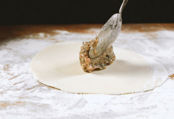 Chef cook making dumplings, manti, khinkali  on wooden table. Process preparation georgian meal. food concept.