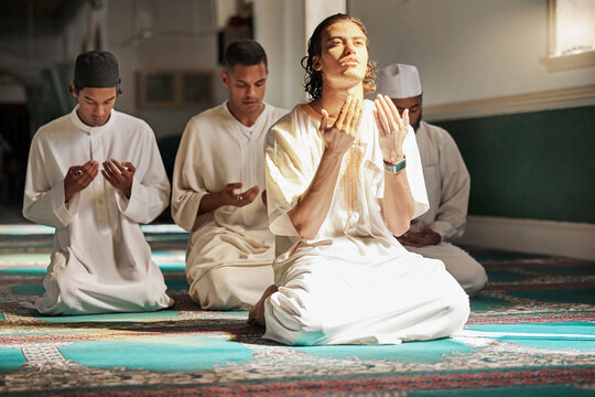 Muslim, prayer and mosque with a spiritual young man holy group praying together in religion while devoted to God. Salah, worship and pray with islamic friends observing ramadan tradition or faith