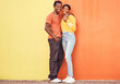 Portrait, love and mockup with a black couple dating outdoor on a color wall background together with mockup. Happy, smile and trust with a man and woman bonding while out in town on a summer day