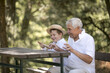 © Maria - Happy senior man Grandfather with cute little boy grandson playing in forest