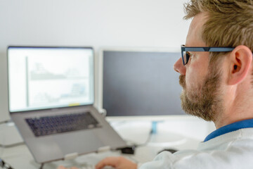 Computer programmer writing program code on computer in office