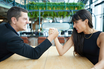 man and woman arm wrestling competition on the table