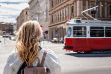 Woman Looking At Passing Tram In Vienna. Tramway Public Transportation