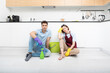 © Vitaliy - Tired couple sitting on the floor after exhausted cleaning day at home