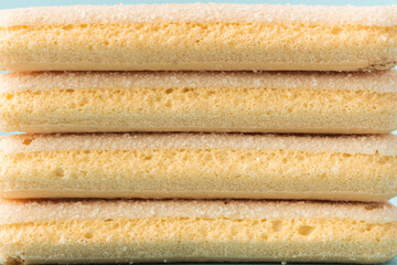 Wall Mural - Traditional Italian savoiardi ladyfinger cookies stacked together as a textured background. Macro shot of sweet sponge biscuits for tiramisu cake.