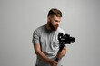 © Volodymyr - Side view of professional bearded videographer, cinematographer, cameraman using camera on gimbal stabilizer, steadicam on white background.