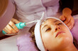 young woman performing cleansing treatment peeling rejuvenating facial treatment in a SPA.  Cosmetology, ionization, Using High frequency  D'Arsonval for skin care.