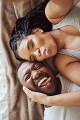 Wall Mural - Black couple, love and bedroom selfie while happy and funny together with tongue out on bed at home, apartment or hotel. Portrait of a young man and woman in a happy marriage with commitment and care