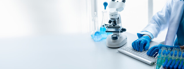 Lab assistant, a medical scientist, a chemistry researcher holds a glass tube through the blood sample, does a chemical experiment and examines a patient's blood sample. Medicine and research concept.