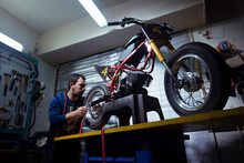 Low Angle View Of Engineer Repairing Motorcycle At Garage
