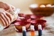 © Cavan Images - A mother pours vinegar into bowls of organic Easter egg dye, to begin the process of coloring organic eggs for Easter. The vinegar helps set the dye.