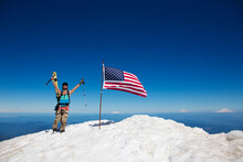 Young Man Cheering As He Reaches Top Of Mountain With American Flag, Lakes District, Chile