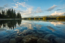 View Of Rocky Lake With Reflection Of Forest And Clouds, British Columbia, Canada
