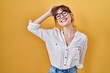 © Krakenimages.com - Young beautiful woman wearing casual shirt over yellow background smiling confident touching hair with hand up gesture, posing attractive and fashionable