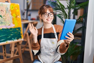 Poster - Young beautiful artist woman doing video call with tablet looking positive and happy standing and smiling with a confident smile showing teeth