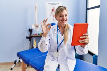 Sticker - Beautiful woman working at pain recovery clinic doing video call doing ok sign with fingers, smiling friendly gesturing excellent symbol