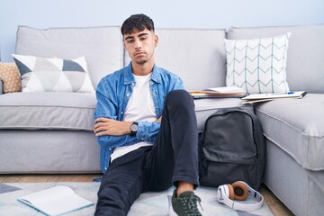 Wall Mural - Young hispanic man sitting on the floor studying for university looking sleepy and tired, exhausted for fatigue and hangover, lazy eyes in the morning.