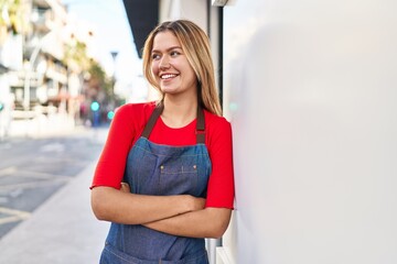 Poster - Young hispanic woman shop assistant standing with arms crossed gesture at street