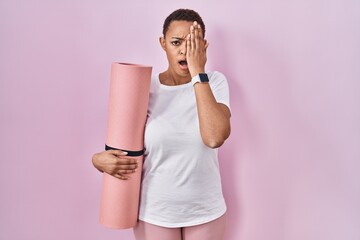 Sticker - Beautiful african american woman holding yoga mat yawning tired covering half face, eye and mouth with hand. face hurts in pain.