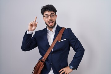 Sticker - Hispanic man with beard wearing business clothes pointing finger up with successful idea. exited and happy. number one.