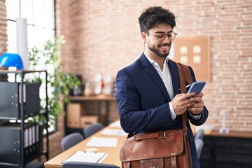 Sticker - Young hispanic man business worker using smartphone at office