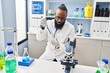 © Krakenimages.com - Young african american man wearing scientist uniform using pipette at laboratory