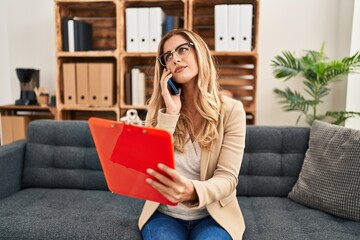 Poster - Young blonde woman psychologist talking on the smartphone at psychology center