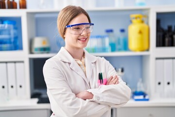 Poster - Young blonde woman wearing scientist uniform standing with arms crossed gesture at laboratory