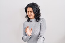 Hispanic Woman With Dark Hair Standing Over Isolated Background Disgusted Expression, Displeased And Fearful Doing Disgust Face Because Aversion Reaction.
