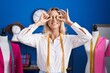 © Krakenimages.com - Young blonde woman tailor smiling confident holding buttons over eyes at tailor shop
