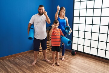 Wall Mural - Family of three holding yoga mat annoyed and frustrated shouting with anger, yelling crazy with anger and hand raised