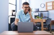 © Krakenimages.com - African american man business worker talking on the smartphone using laptop at office