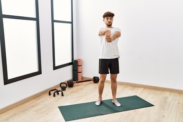 Poster - Young arab man stretching at sport center