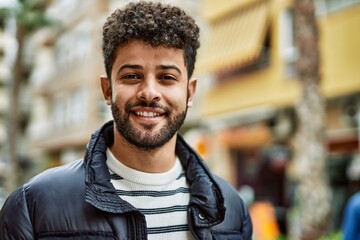 Canvas Print - Young arab man smiling outdoor at the town