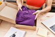 © Krakenimages.com - Young hispanic woman packing clothes box at warehouse