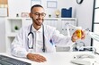 © Krakenimages.com - Young hispanic man wearing doctor uniform holding pills at clinic