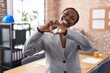 © Krakenimages.com - African american woman at the office smiling in love showing heart symbol and shape with hands. romantic concept.