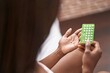 © Krakenimages.com - African american woman holding birth control pills sitting on bed at bedroom