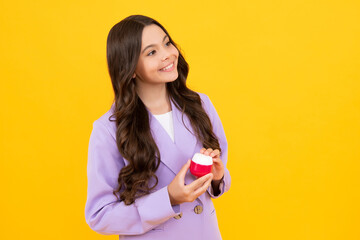 Canvas Print - Teenage girl hold facial cleaner for skin wash, cleansing scrub. Child presenting cosmetic product for teen. Kid use face cream isolated on yellow background.